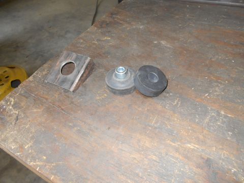 1992 Ford Bronco - Metal bracket and rubber mounts are shown on a workbench.