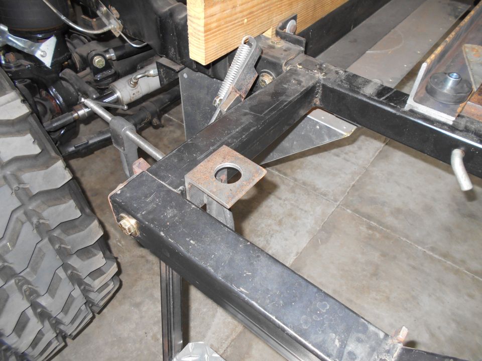 close-up of vehicle frame with suspension parts and large tire