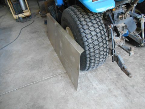 1992 Ford Bronco - A metal plate is attached to the side of a lawn tractor's large rear tire.