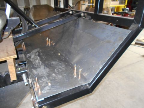 1992 Ford Bronco - A metal tray with copper studs is attached to a black metal frame, seen from a close-up angle.