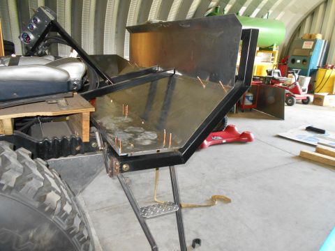 1992 Ford Bronco - This image shows a custom metal structure being built onto a vehicle, with a large tire in the foreground.