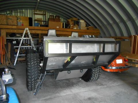 1992 Ford Bronco - A custom trailer chassis is shown in a garage, with an orange vehicle visible in the background.