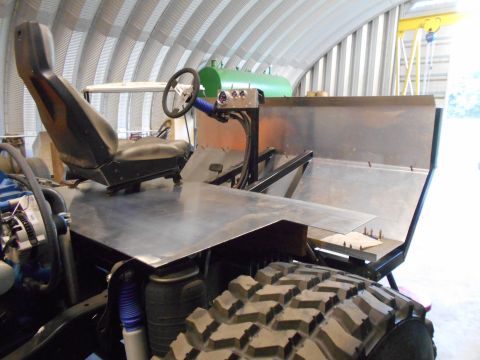 1992 Ford Bronco - The interior of a custom-built vehicle shows a single bucket seat and a metal dashboard with a steering wheel.