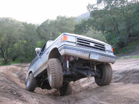 1989 Ford Bronco - This 1989 Ford Bronco navigates a challenging off-road trail, its robust suspension and all-terrain tires.
