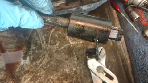 1996 Ford Bronco - Close-up of a mechanical part being worked on with tools.