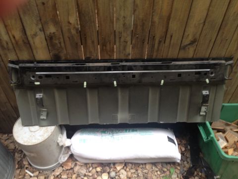 2001 Ford Ranger - Olive green and black truck tailgate shown mounted on buckets against a wooden fence.
