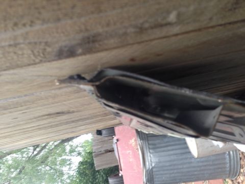 2001 Ford Ranger - A dark metal vehicle frame part is visible against a background of wooden planks.