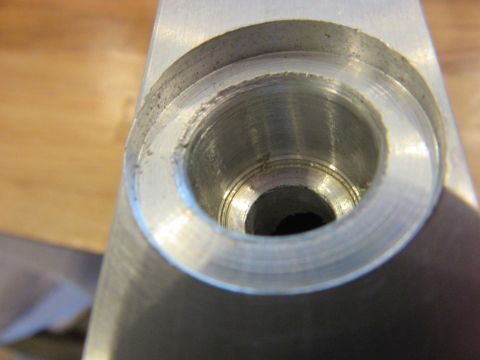 Close-up of a machined metal part with a threaded opening