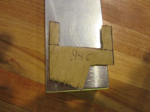 Cardboard template with .945 measurement on metal surface