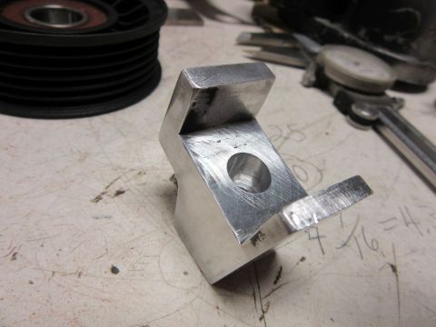 metal bracket with hole and pulley on workbench