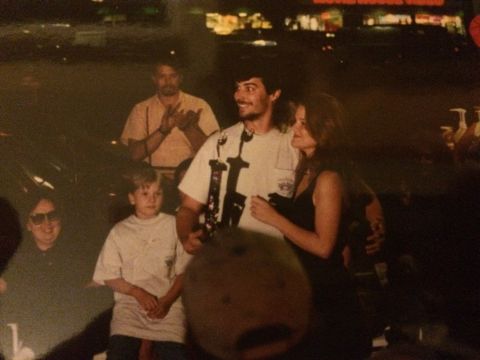 1989 Ford Bronco - A group of people are seen outdoors at night, with a man and woman embracing in the foreground.