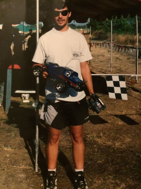 1989 Ford Bronco - Man with remote control car and controller at an outdoor event with a checkered flag.