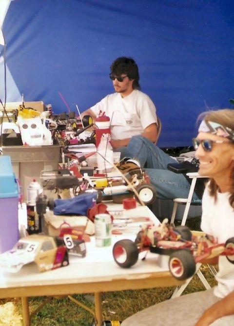 1989 Ford Bronco - People are gathered around a table filled with remote control cars and related equipment.