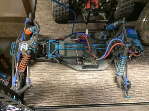1989 Ford Bronco - The chassis of a remote control car is visible, showing its internal components and suspension system.