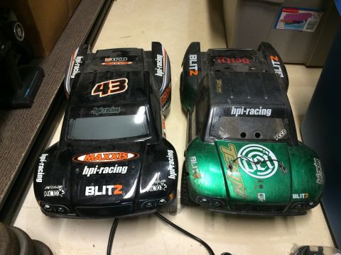 1989 Ford Bronco - Two remote-controlled car bodies, one black and one green, sit side-by-side.