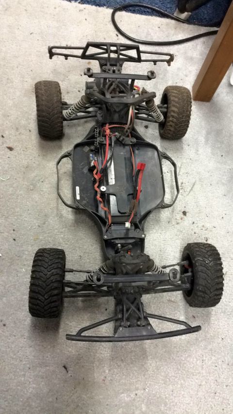 1989 Ford Bronco - The chassis of a remote-controlled car is shown from a top-down perspective, revealing its internal components and suspension.