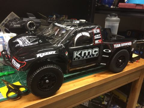 1989 Ford Bronco - RC10T RC truck with KMC Wheels and Team Associated decals on a workbench.