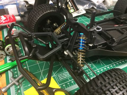 1989 Ford Bronco - The intricate suspension system of a remote control car, blue shock absorbers and gold springs, is shown in detail.