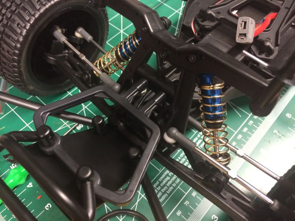 Remote control car chassis with gold springs and blue shock absorbers, viewed from above