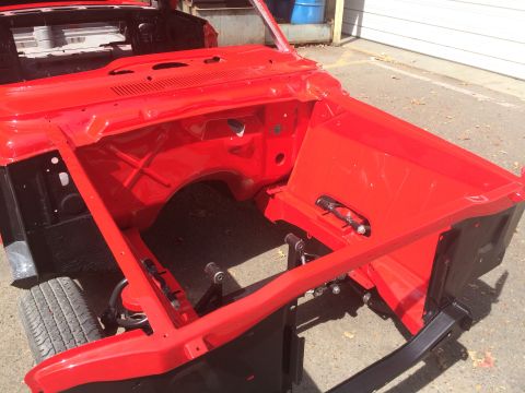 1964 Ford Fairlane - The bare metal chassis of a car is shown, painted bright red, ready for further restoration work.
