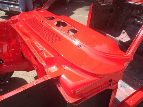 1964 Ford Fairlane - The red body shell of a 1964 Ford Fairlane is shown from the front, revealing the firewall and inner fender structures.