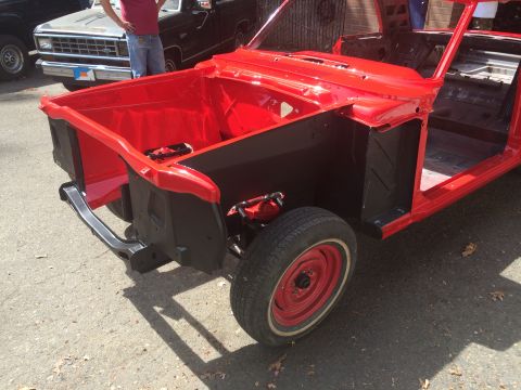 1964 Ford Fairlane - The front section of a red 1964 Ford Fairlane, stripped down for restoration, is shown from the front. Another vehicle is visible in the ba…