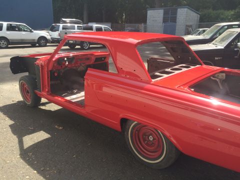 1964 Ford Fairlane - A red 1964 Ford Fairlane body is shown from a 3q-front angle, appearing to be in the process of restoration with its interior and engine ba…