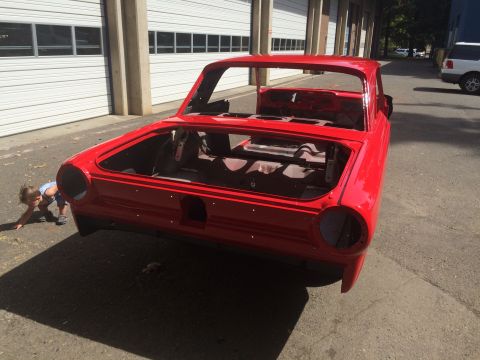 1964 Ford Fairlane - Red 1964 Ford Fairlane body shell undergoing restoration, parked outdoors.