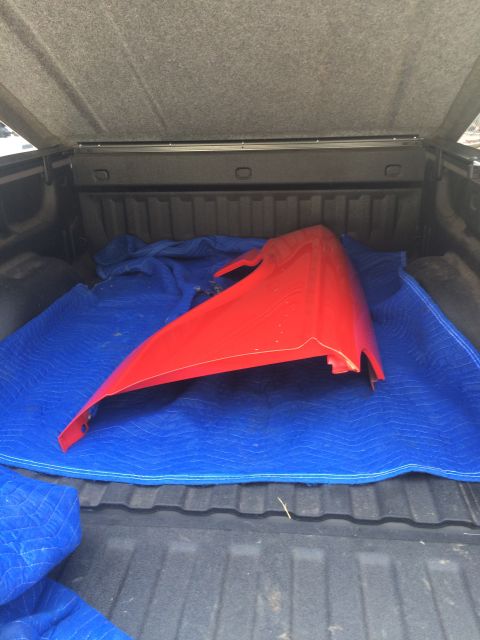 1964 Ford Fairlane - A red car fender is placed on moving blankets inside a truck bed.