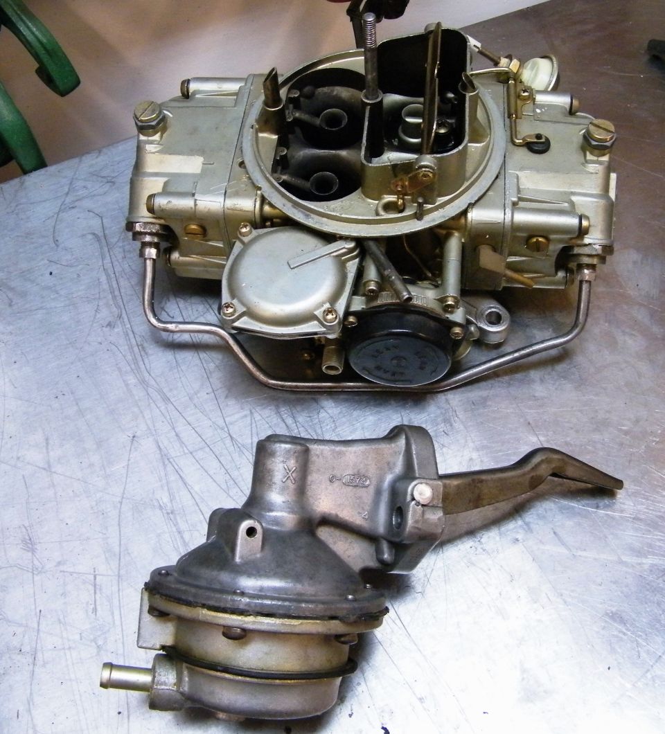 Carburetor and fuel pump on a metal surface