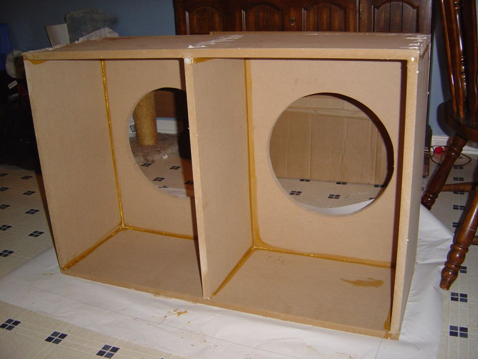 Homemade dual-chamber MDF subwoofer box with two round driver cutouts