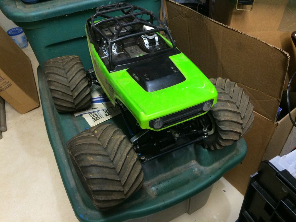 Green remote control monster truck with large tires on a green bin.