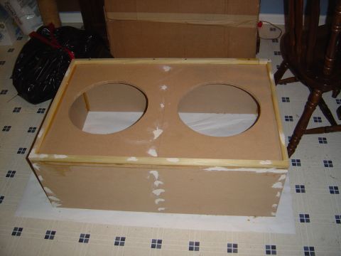 1986 Ford Bronco - A homemade MDF speaker/subwoofer enclosure with two circular cutouts for drivers, edged with wood trim and dabs of wood filler, sitting on…