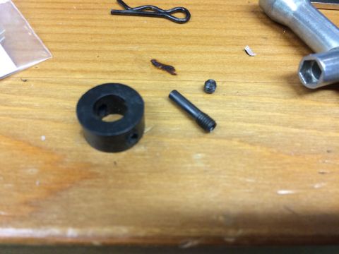 1989 Ford Bronco - A collection of small metal parts, including a black cylindrical piece with a hole through the center, a small screw, and a longer screw wi…