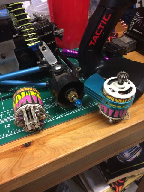 1989 Ford Bronco - Close-up of two electric motors and a remote control transmitter, likely for an RC car. The motors have colorful labels, and the transmitte…
