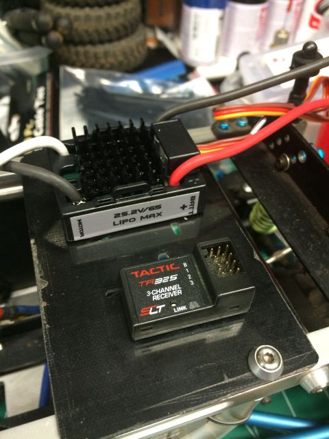 1989 Ford Bronco - A close-up view of electronic components for an RC vehicle, including an ESC and a receiver, mounted on a black surface.