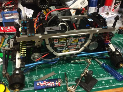 1989 Ford Bronco - A close-up, overhead view of the chassis of a remote-controlled car, showing various electronic components, suspension, and a collection of…