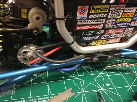 1989 Ford Bronco - Close-up view of the electrical connections and motor of an RC car, with various sponsor decals visible on the chassis.