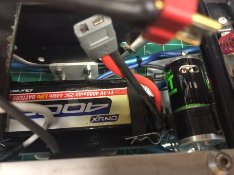 1989 Ford Bronco - A close-up view shows the internal components of an RC vehicle, including a black and green electric motor and a "400" branded LiPo battery…