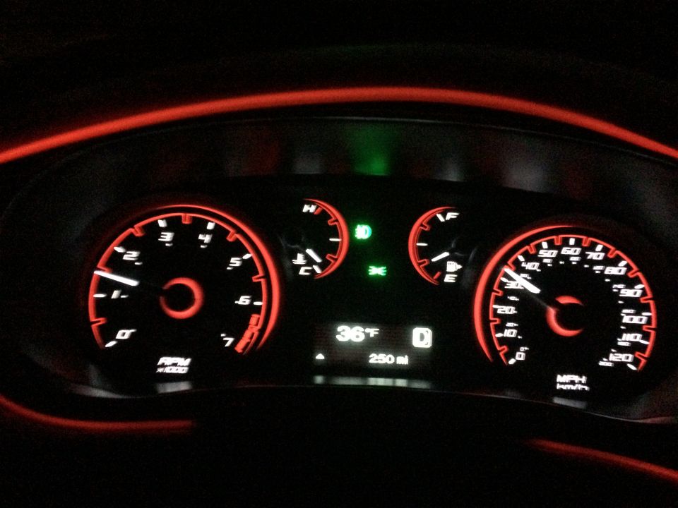 Dashboard of a 2015 Dodge Dart with red illuminated gauges and digital display.
