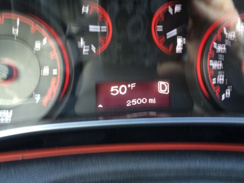 2015 Dodge Dart - The interior dashboard shows various gauges and a digital display with a warning light illuminated.