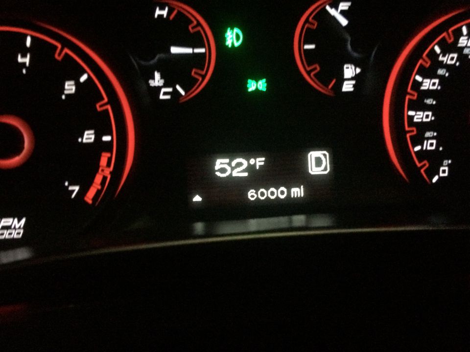 Dashboard gauges showing 52F, 6000 miles, and D for drive. The tachometer reads up to 7000 RPM