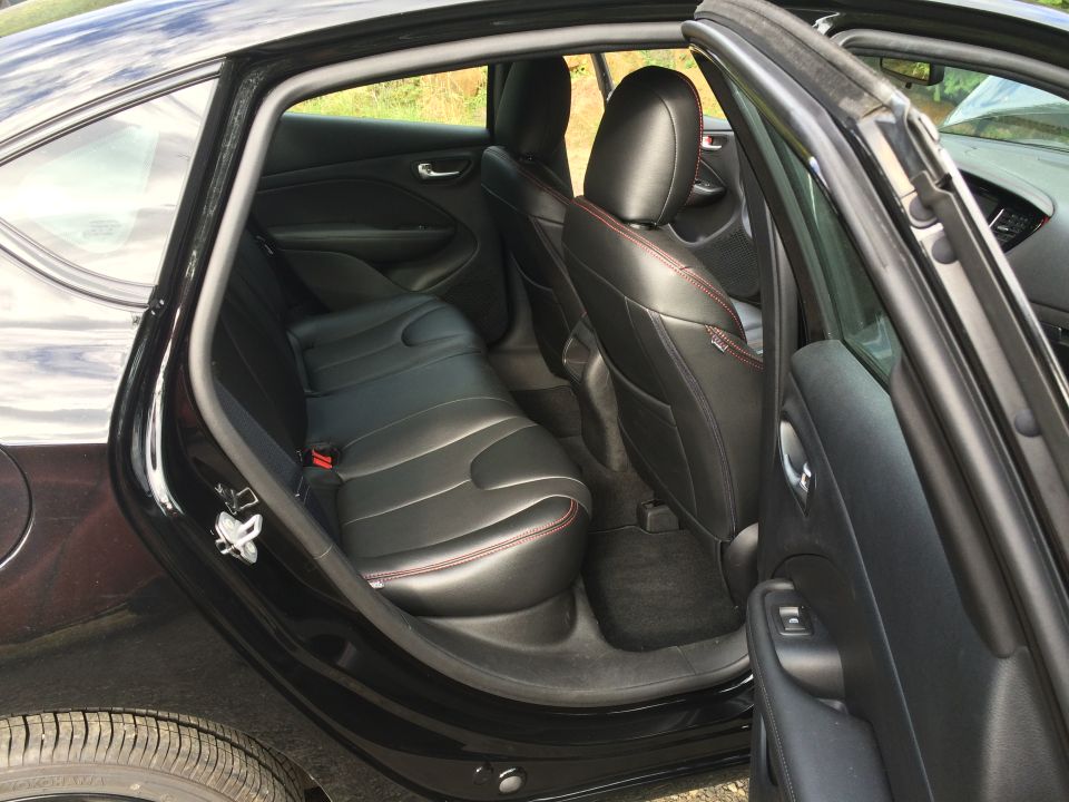 Black 2015 Dodge Dart rear interior with open rear door, showing leather seats with red stitching.