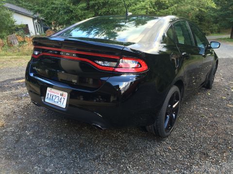 2015 Dodge Dart - The rear passenger side of a black 2015 Dodge Dart sedan is shown parked on a gravel driveway. The license plate reads "WASHINGTON AXK2347".