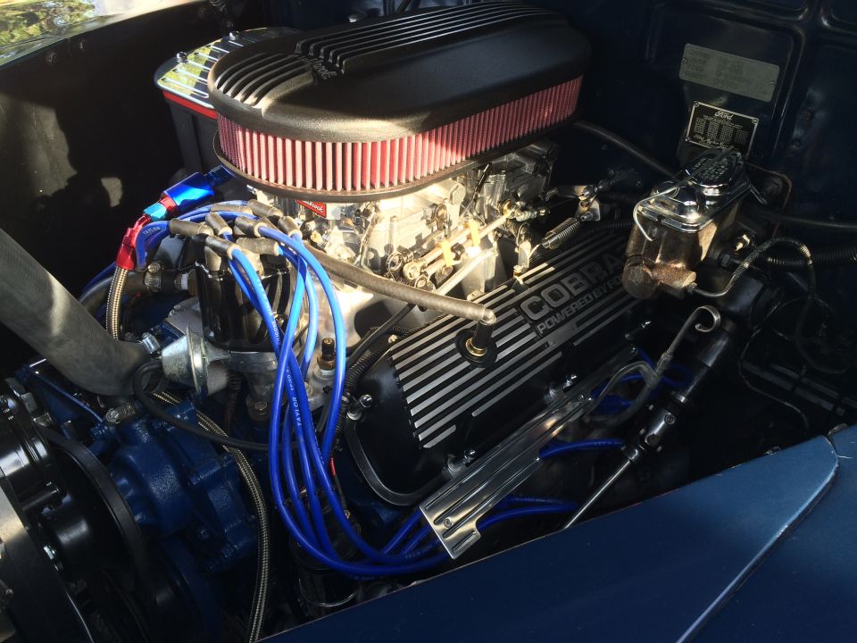 Custom engine bay with Cobra valve covers and blue spark plug wires.
