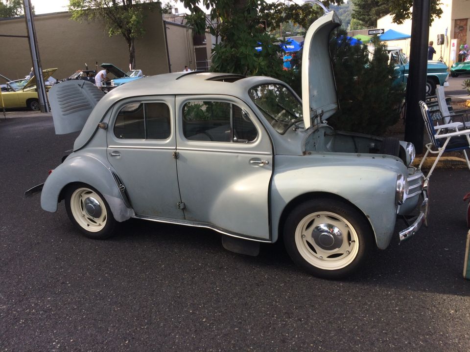 Light blue vintage car with hood and trunk open, white-rimmed wheels, sunroof.