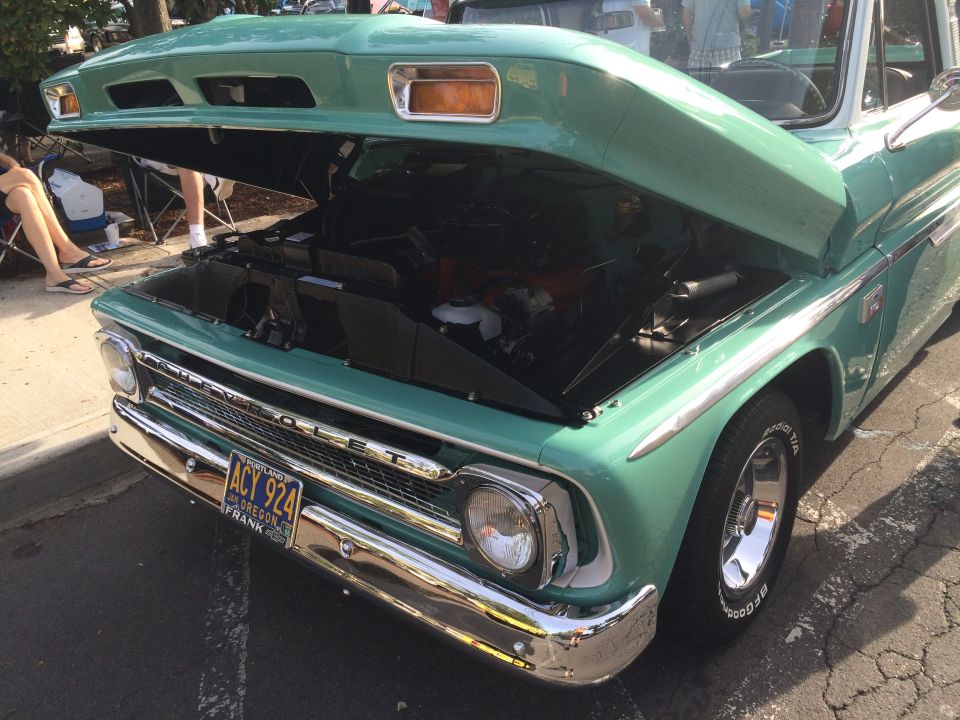 Teal and white 1962 Chevrolet Suburban with hood open, showing engine and chrome front end.