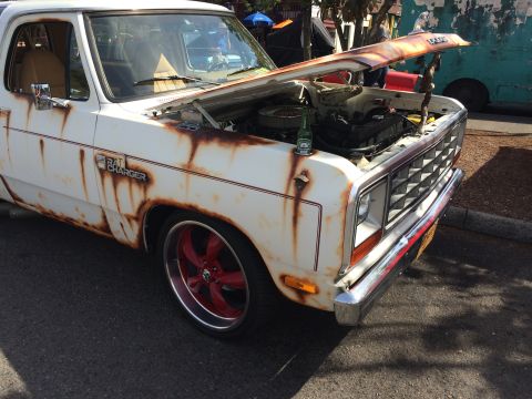1962 Chevrolet Suburban - A heavily rusted white Dodge pickup truck with the hood open, revealing the engine. A bottle of beer rests on the fender next to a bottle o…