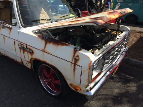 1962 Chevrolet Suburban - A heavily rusted white Dodge Ram pickup truck with its hood open, revealing the engine bay. A bottle of Heineken rests on the fender next t…