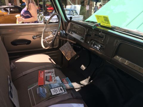 1962 Chevrolet Suburban - The interior of a vintage Chevrolet truck is shown, focusing on the driver's side seat and dashboard. Several vintage automotive brochures…